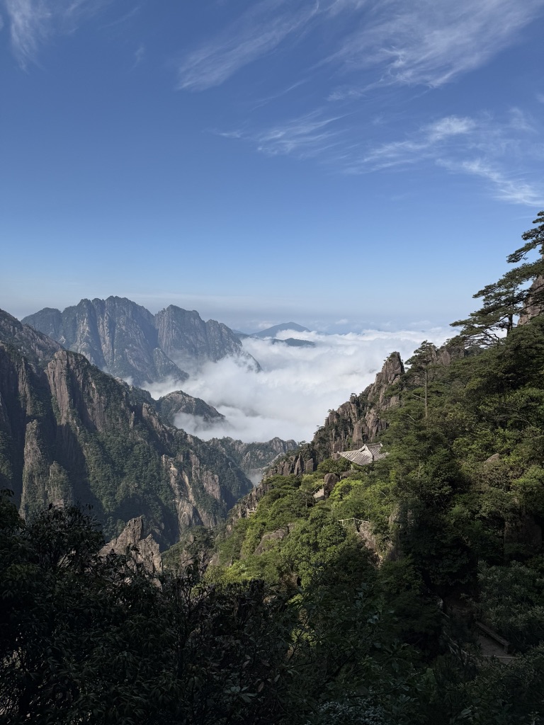 Green mountain peaks above the clouds